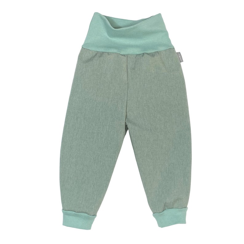 May include: A pair of light green trousers with a wide elastic waistband. The trousers have a cuffed hem and are made of a soft, comfortable fabric.