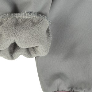 May include: Close-up of the grey fleece lining inside the cuff of a grey jacket.