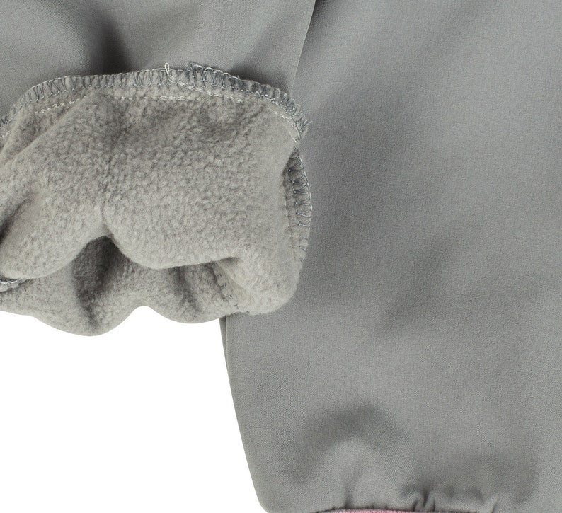 May include: Close-up of the grey fleece lining inside the cuff of a grey jacket.