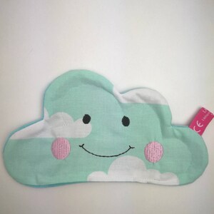 Könnte beinhalten: Ein hellblaues und weißes, wolkenförmiges Plüschtier mit einem lächelnden Gesicht und rosa Wangen. Das Spielzeug hat ein CE-Label.