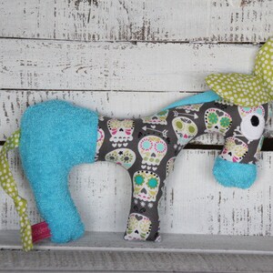 以下が含まれることがあります： 青と白のストライプの体、緑と白のドットの耳、グレーと白の骸骨模様のぬいぐるみ馬。