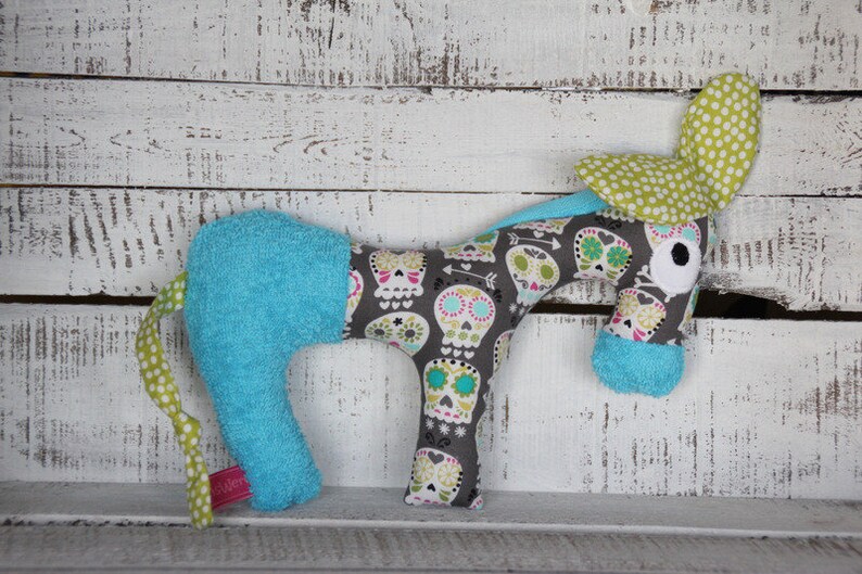 以下が含まれることがあります： 青と白のストライプの体、緑と白のドットの耳、グレーと白の骸骨模様のぬいぐるみ馬。