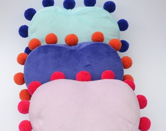 Heart pillow decorated with pompoms