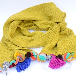 Large scarves with pompoms and tassels.