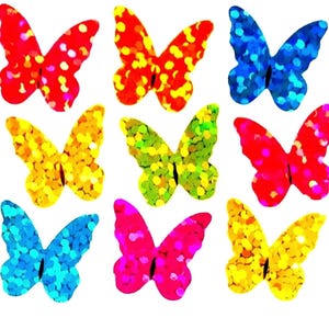 May include: A collection of nine butterfly-shaped cutouts arranged in a grid. Each butterfly features a distinct, vibrant color including red, orange, yellow, green, blue, and pink, all with a shimmering, glittery, and reflective surface texture.