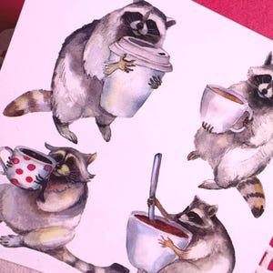 May include: A watercolor illustration featuring four raccoons interacting with various drink containers. One raccoon holds a large travel mug, another a white teacup, a third a polka-dot mug, and the fourth stirs a large white mug with a spoon.