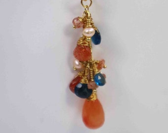 May include: A gold chain necklace with a pendant featuring a cluster of orange, blue, and white gemstones wrapped in gold wire.