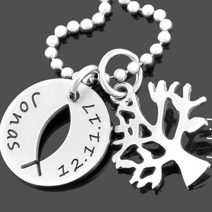 May include: Silver necklace with a round pendant featuring a fish symbol and the text "John 12:27" and a tree of life charm.