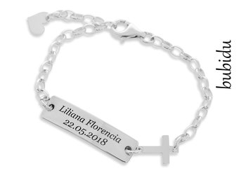May include: Silver bracelet with a cross charm and a rectangular tag engraved with "Liliana Florencia 22.05.2018".