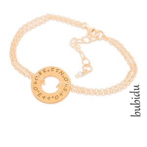 Può includere: Bracciale in oro con un ciondolo rotondo che presenta i numeri da 0 a 9 e le lettere I, N, O e Z. Il ciondolo è attaccato a una catena delicata con un piccolo accento di perla.
