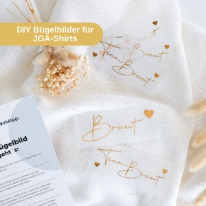 Könnte beinhalten: Vier goldene Bügelbilder auf weißem Papier. Die Transfers zeigen die Wörter "Team Braut" und "Braut" mit kleinen goldenen Herzen.  DIY Bügelbilder für JGA-Shirts.