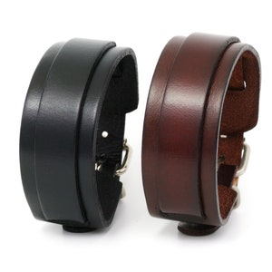 May include: Two leather watch bands, one black and one brown, with silver buckles.