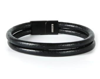 May include: A black leather bracelet with a double wrap and a black metal clasp. The clasp has the word "ARGENTO" engraved on it.