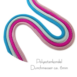 Può includere: Quattro cordoncini colorati in poliestere nelle tonalità del blu, rosa e verde chiaro, ciascuno di circa 6 mm di diametro. I cordoncini sono disposti in un motivo curvo su sfondo bianco. Il testo "Polyesterkordel Durchmesser ca. 6mm" è visibile.
