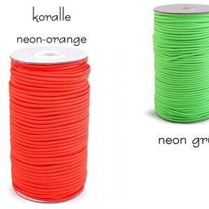 Pu&ograve; includere: Due bobine di cordoncino elastico, una arancione neon e una verde neon. Le bobine sono etichettate "koralle neon-orange" e "neon gr&uuml;n".