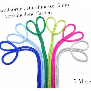 Pode incluir: Uma variedade de cordões de algodão em diferentes cores, cada um com 5 metros de comprimento e 5 mm de diâmetro. Os cordões estão dispostos em forma de leque, com as pontas de cada cordão formando um laço.