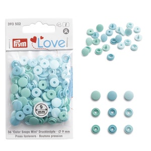 Puede incluir: Un paquete de 36 corchetes 'Color Snaps Mini' en tonos azules y verdes. El paquete incluye diferentes tamaños, con un diámetro de 9 mm. La marca 'Love' es visible en el embalaje.