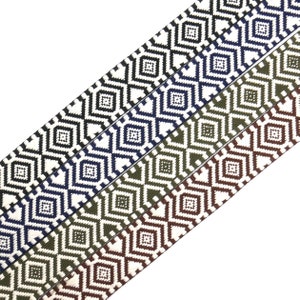 Op de afbeelding: Vier verschillende gekleurde geweven elastieken met een geometrisch ruitpatroon. De elastieken zijn wit met zwart, wit met donkerblauw, wit met olijfgroen en wit met bruin.