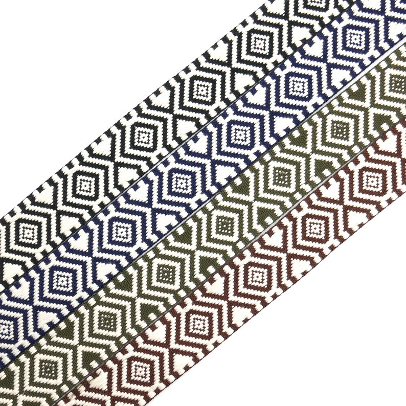 K&ouml;nnte beinhalten: Vier verschiedene farbige gewebte Gummib&auml;nder mit einem geometrischen Rautenmuster. Die B&auml;nder sind wei&szlig; mit schwarz, wei&szlig; mit marineblau, wei&szlig; mit olivgr&uuml;n und wei&szlig; mit braun.