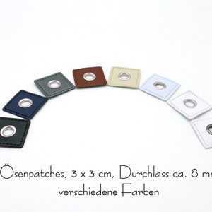 Op de afbeelding: Assortiment van acht leren patches met oogjes, elk 3 cm bij 3 cm groot. De patches zijn in verschillende kleuren, waaronder zwart, donkerblauw, grijs, bruin, beige, lichtblauw en wit. De oogjes zijn zilverkleurig en hebben een diameter van ongeveer 8 mm. "Ösenpatches, 3 x 3 cm, Durchlass ca. 8 mm verschiedene Farben" staat onder de patches.