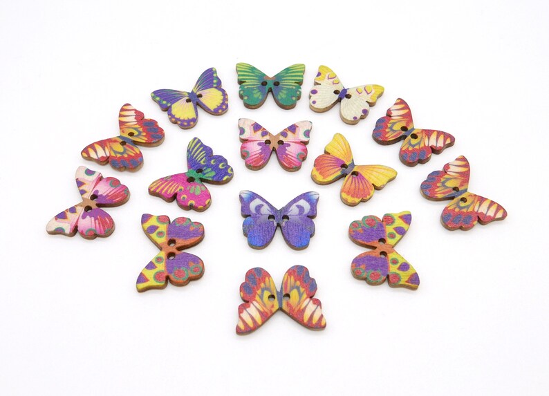 May include: Assortment of 15 wooden butterfly buttons with colorful painted designs. The buttons are approximately 2 cm in size and have two holes for sewing.