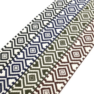 K&ouml;nnte beinhalten: Vier verschiedene Farben von gewebtem Besatz mit einem geometrischen Rautenmuster. Der Besatz ist wei&szlig; mit schwarzen, dunkelblauen, gr&uuml;nen und braunen Rauten.