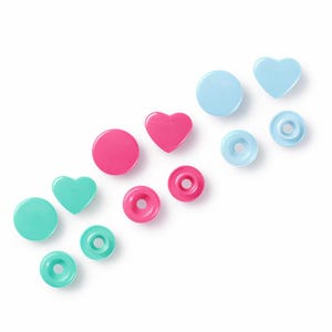 May include: A collection of colourful press studs in various shapes, including circles and hearts. The press studs are in shades of pink, teal, and light blue. The image is a top-down view on a white background.
