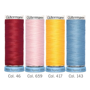 Puede incluir: Cuatro carretes de hilo Gütermann en colores rojo oscuro (Col. 46), rosa claro (Col. 659), amarillo brillante (Col. 417) y azul claro (Col. 143). Cada carrete está etiquetado como "Water Repellent 100m".