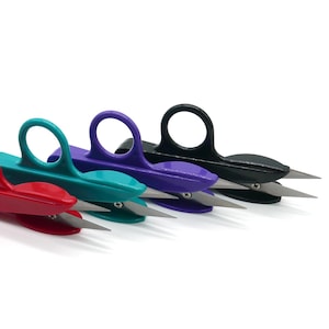 May include: Four pairs of small, finger-ring scissors with different colored handles: red, turquoise, purple, and black.