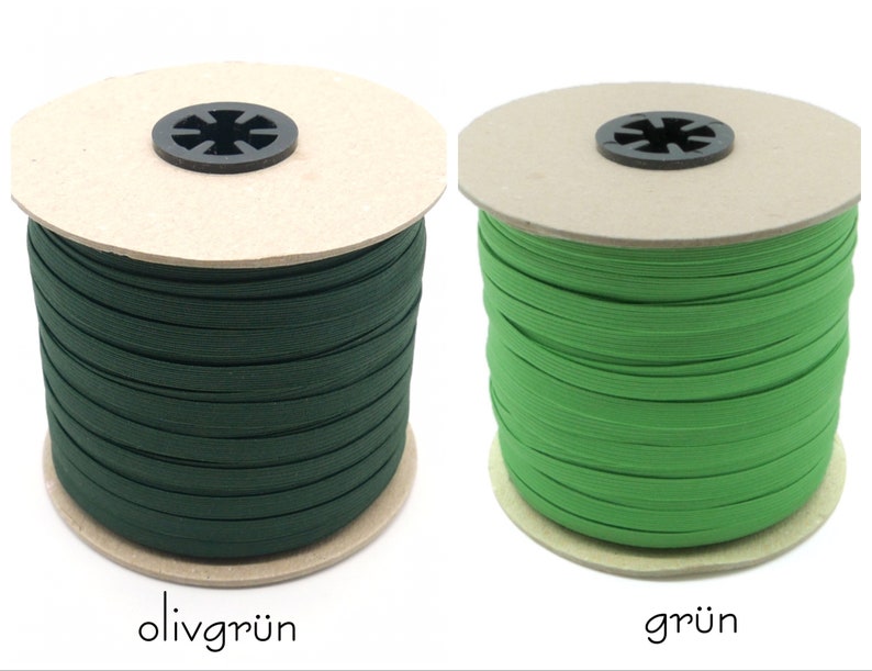 May include: Two spools of elastic cord, one green and one olive green. The spools are made of cardboard and have a label with the color name in German.