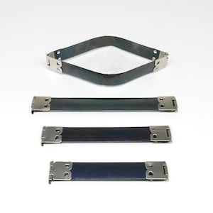 May include: A collection of four dark gray leather straps with silver-colored metal clasps. One strap is bent into a diamond shape. The other three are straight, varying in length. The straps are set against a white background.