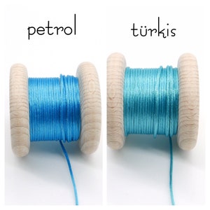 Peut inclure: Deux bobines en bois avec du fil, l'une &eacute;tiquet&eacute;e petrol avec un cordon bleu vif et l'autre &eacute;tiquet&eacute;e t&uuml;rkis avec un cordon turquoise. Les bobines ont une finition en bois clair naturel et sont enroul&eacute;es d'un cordon fin, lisse et brillant.