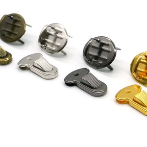 Könnte beinhalten: Sortiment von sechs Metallschließen in Gold-, Silber- und Schwarz-Finish. Die Schließen sind zum Anbringen an Taschen, Geldbörsen oder anderen Lederwaren gedacht.