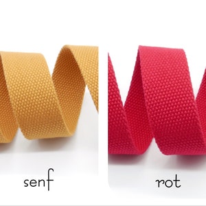 May include: Two rolls of woven cotton webbing, one mustard yellow and one bright red.