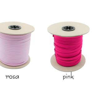 May include: Two spools of elastic cord, one pink and one light pink. The spools are made of cardboard and have a black plastic center.