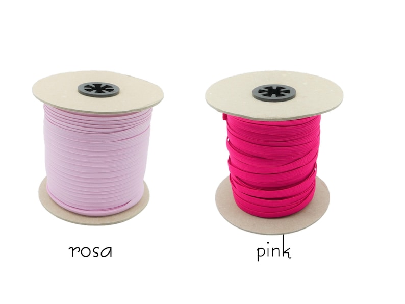 May include: Two spools of elastic cord, one pink and one light pink. The spools are made of cardboard and have a black plastic center.