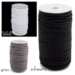 Pu&ograve; includere: Tre bobine di cordoncino elastico in bianco, grigio e nero. Le bobine sono etichettate con "wei&szlig;", "grau" e "schwarz".