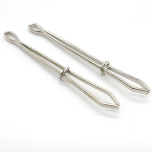 May include: Two silver metal yarn needle threaders. The threaders have a loop at one end and a pointed end at the other.