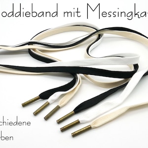 Könnte beinhalten: Ein Set aus drei Schnürsenkeln mit Messingösen. Die Schnürsenkel sind in Schwarz, Weiß und Beige. Der Text "Hoddieband mit Messingkappe" und "verschiedene Farben" ist im Bild zu sehen.