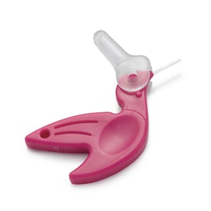 Puede incluir: Un dispositivo médico de color magenta con una punta de plástico transparente y una pequeña cuchilla plateada. El dispositivo tiene un mango curvo con una hendidura ovalada y un pequeño agujero. La punta transparente está orientada hacia arriba.