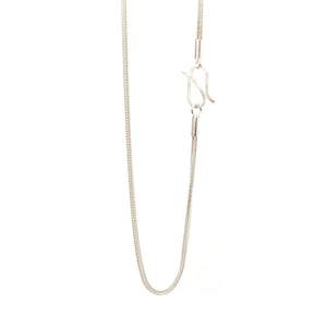 Könnte beinhalten: Eine silberne Kettenkette mit einem Karabinerverschluss.