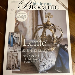 Könnte beinhalten: Magazin "Liefde voor Brocante" mit einer dekorativen Krone auf dem Cover. Das Cover zeigt das Wort "Lente" und den Text "5x Binnenkijken". Das Magazin enthält einen Kalender und Messen.