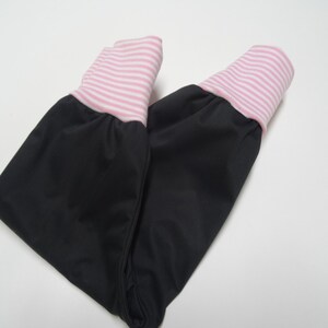 May include: Black pants with pink and white striped cuffs. The pants are folded in half.