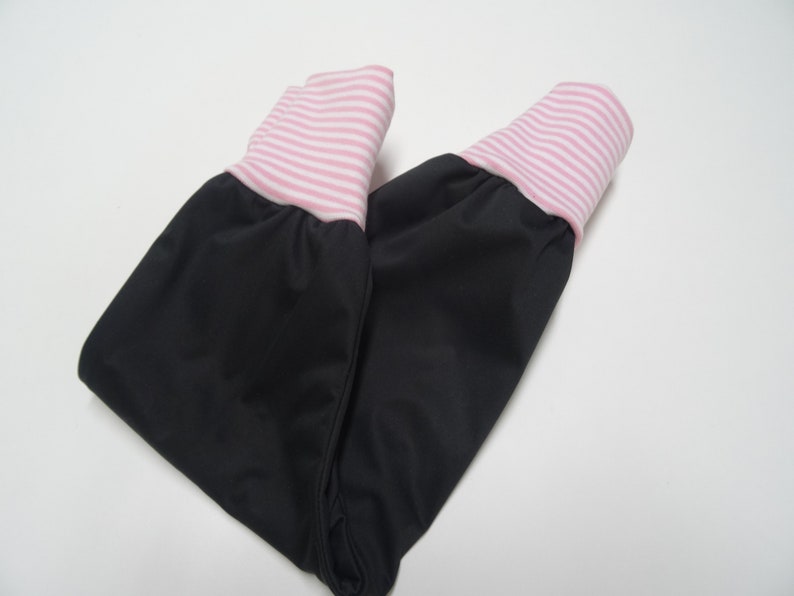 May include: Black pants with pink and white striped cuffs. The pants are folded in half.
