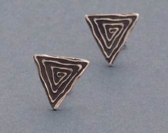 May include: A pair of silver triangle earrings with a black spiral design.