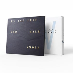 Peut inclure: Une horloge en ardoise noire avec des lettres dorées indiquant "ES IST FÜNF VOR HALB ZWÖLF". Une boîte blanche avec le mot "CLOCK" et un "V" bleu est à côté de l'horloge. Le site web "build-yours.de" est imprimé sur la boîte.