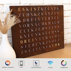 May include: A rusty metal wall clock with white numbers spelling out the German words for numbers one through twelve. The clock has a modern design and is perfect for a contemporary home.