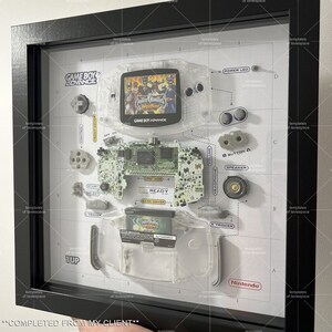Może przedstawiać: Rozebrana konsola do gier Game Boy Advance z wkładką do gry Power Rangers. Konsola jest wyświetlana na białym tle z etykietami i diagramami komponent&oacute;w konsoli.