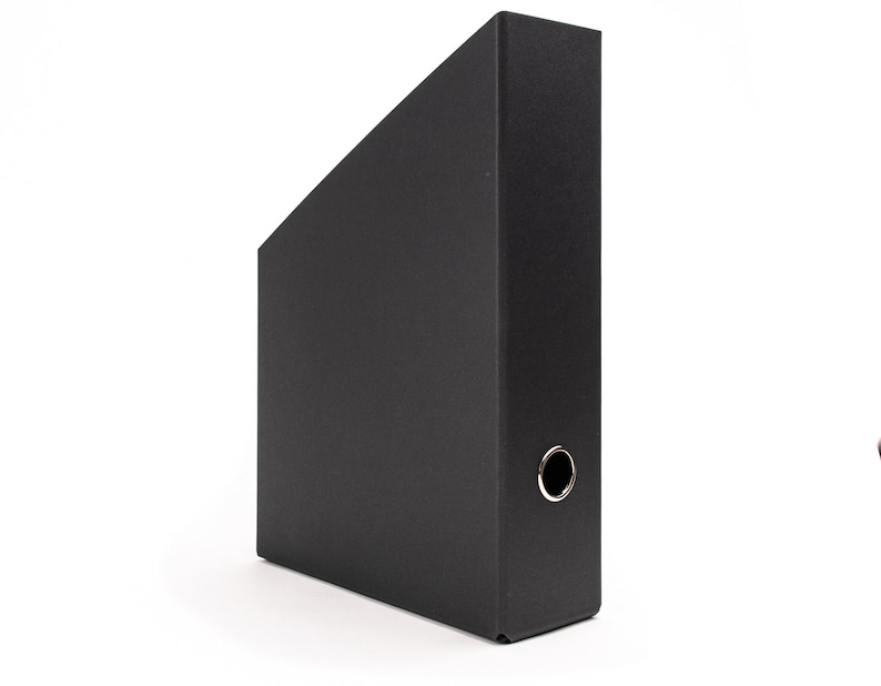May include: A black hanging file folder with a metal ring on the side.