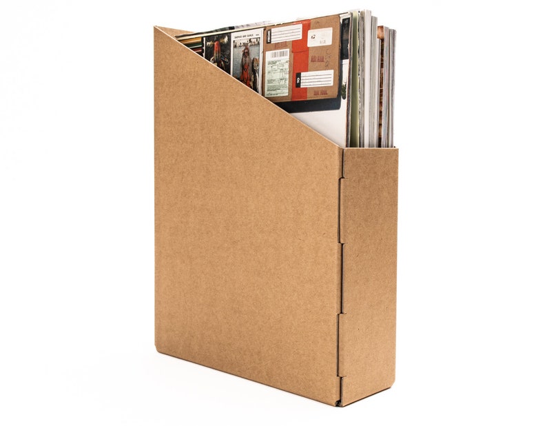 May include: A brown cardboard magazine holder with a slanted opening for inserting magazines. The holder is empty.